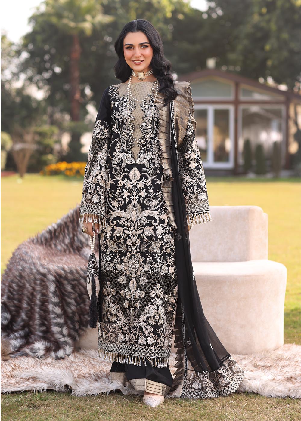 Model wearing black and gold embroidered dress with matching dupatta from Musferah Saad Pretty Girls Luxury Lawn 2025 Lustre. Pakistani clothes online UK.