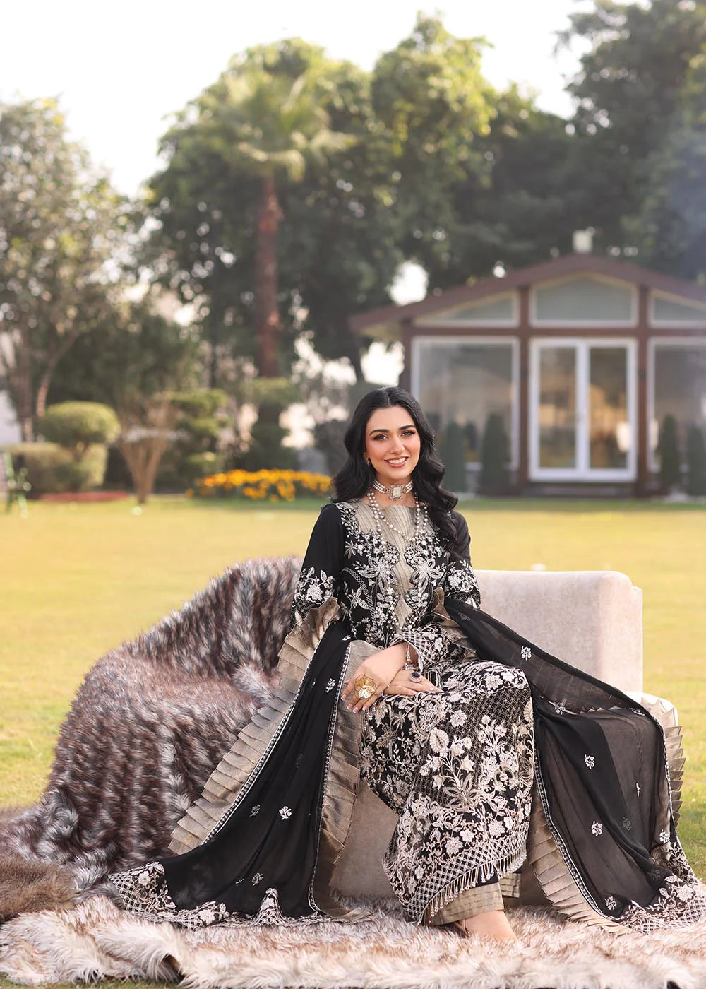 Model wearing black and gold embroidered dress with matching dupatta from Musferah Saad Pretty Girls Luxury Lawn 2025 Lustre. Pakistani clothes online UK.