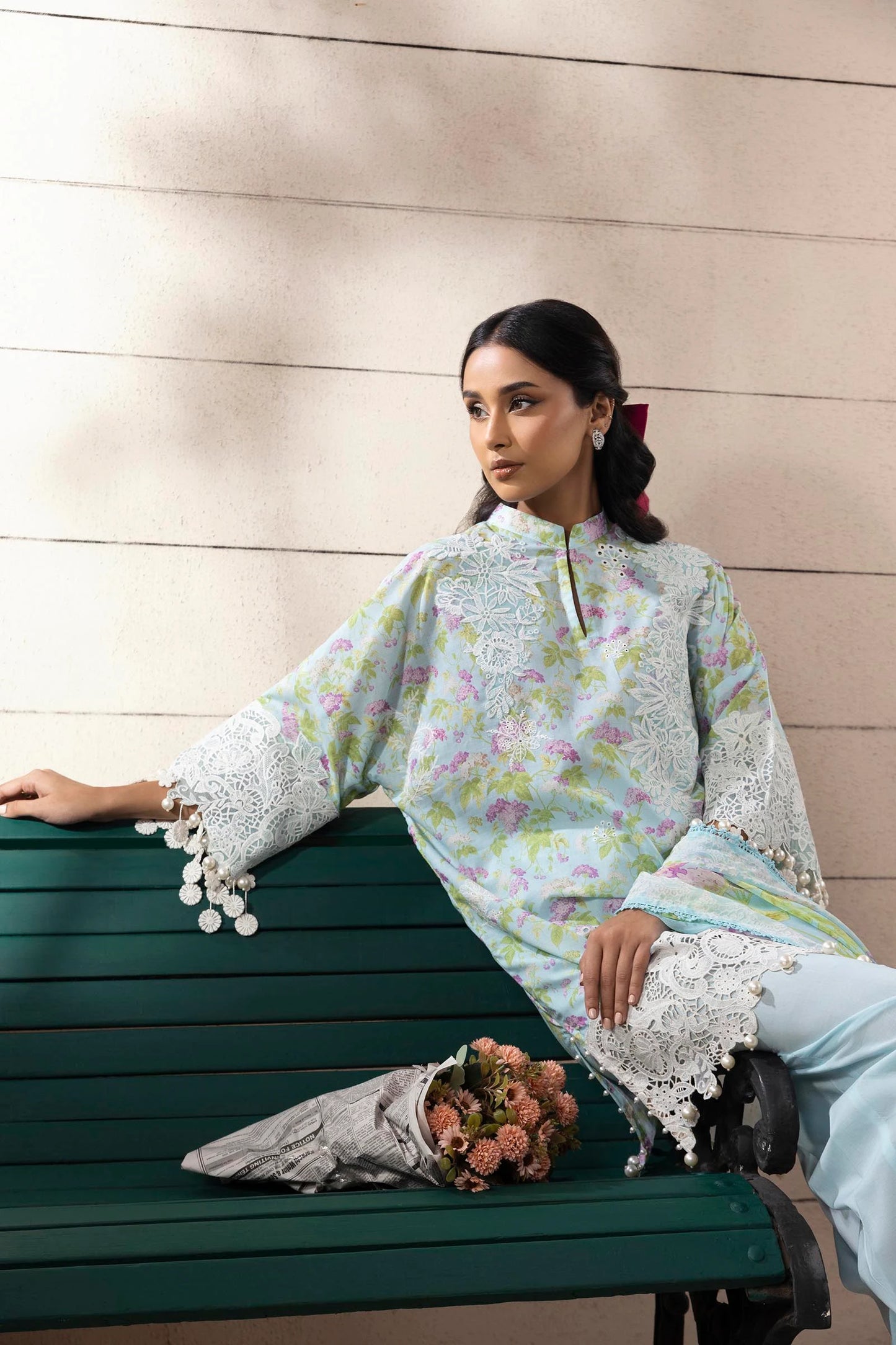 Model wearing aqua blue floral printed dress with white lace detailing from Sana Safinaz Muzlin Spring '25, Pakistani clothes online UK.