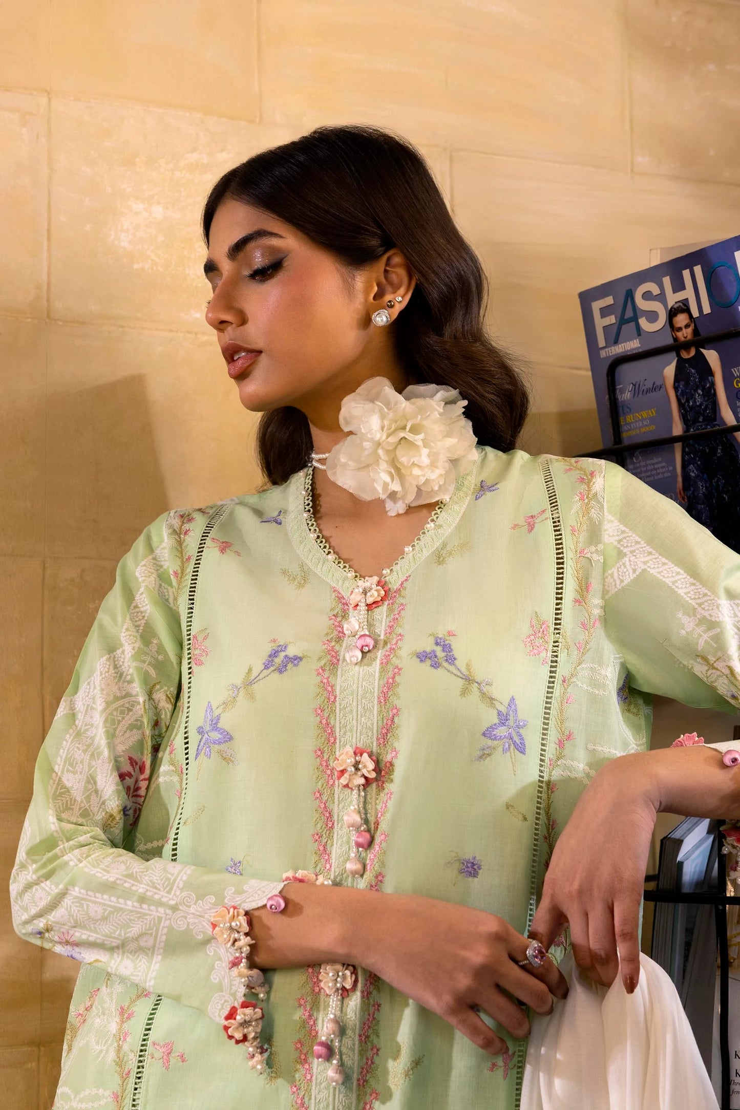 Model wearing pastel green embroidered dress with multicolor striped dupatta from Sana Safinaz Muzlin Spring '25, Pakistani Luxury pret UK.