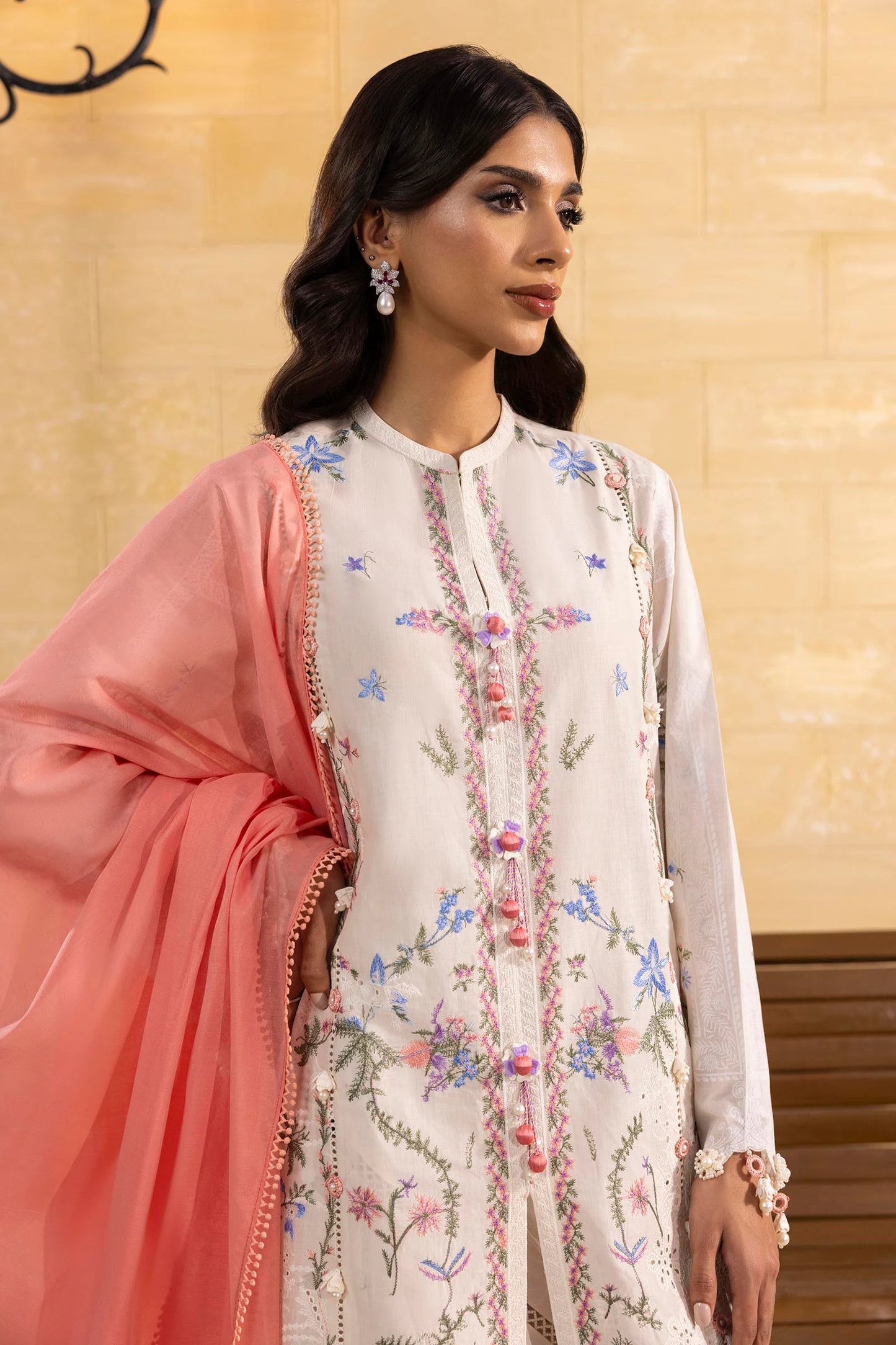 Model wearing off-white embroidered dress with peach and blue dupatta from Sana Safinaz Muzlin Spring '25, Pakistani Luxury pret UK.