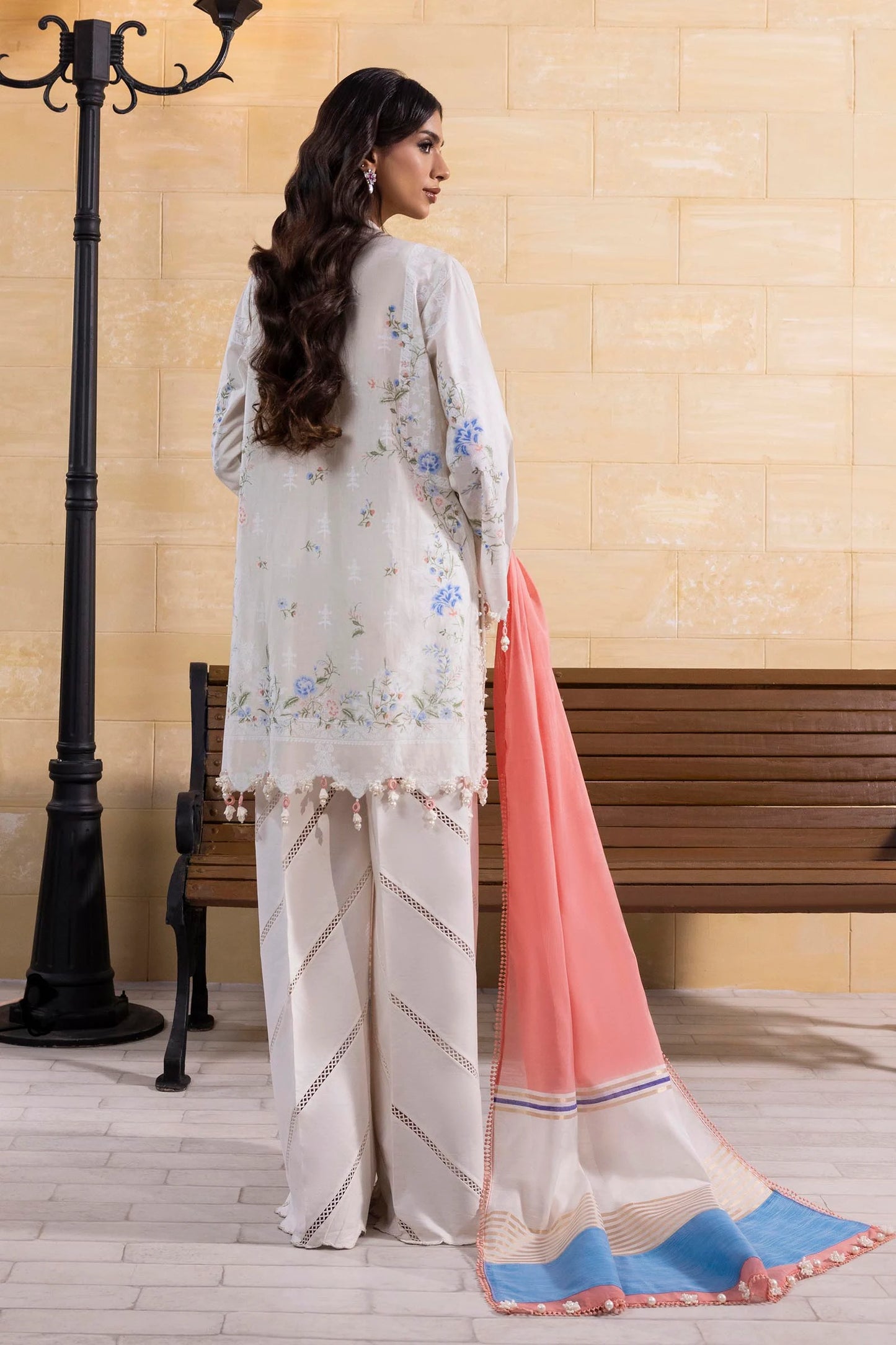 Model wearing off-white embroidered dress with peach and blue dupatta from Sana Safinaz Muzlin Spring '25, Pakistani Luxury pret UK.
