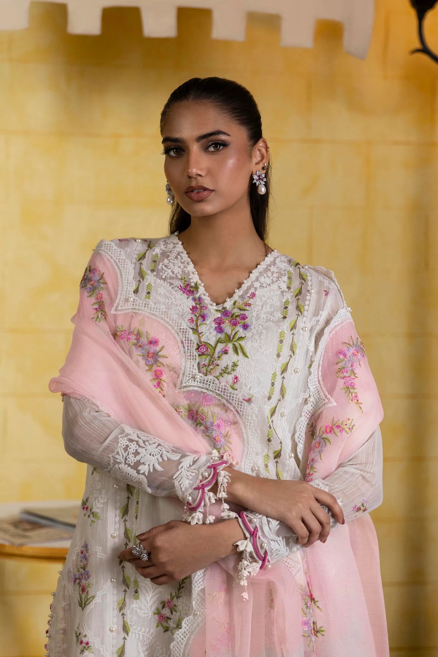 Model wearing ivory embroidered dress with pink scalloped dupatta from Sana Safinaz Muzlin Spring '25, Pakistani Luxury pret in UK.