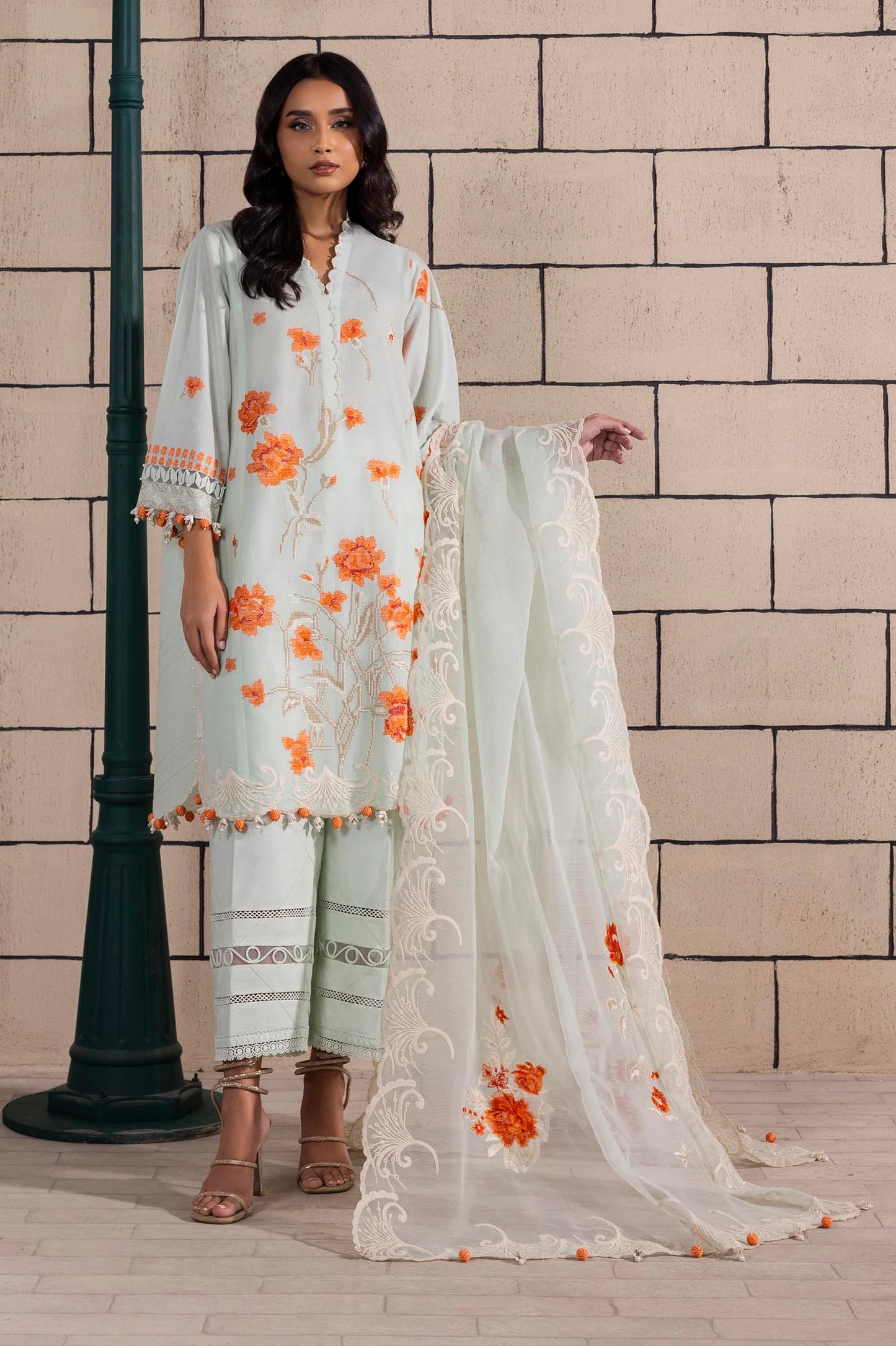 Model wearing mint green dress with orange floral embroidery and matching dupatta from Sana Safinaz Muzlin Spring '25, Pakistani Luxury pret UK.
