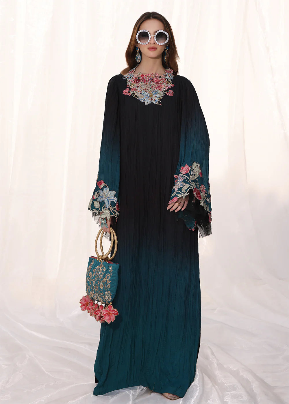 Model wearing ombre black and teal embroidered pleated dress from Musferah Saad Moonlit Glam, Pakistani Luxury pret available online in UK.
