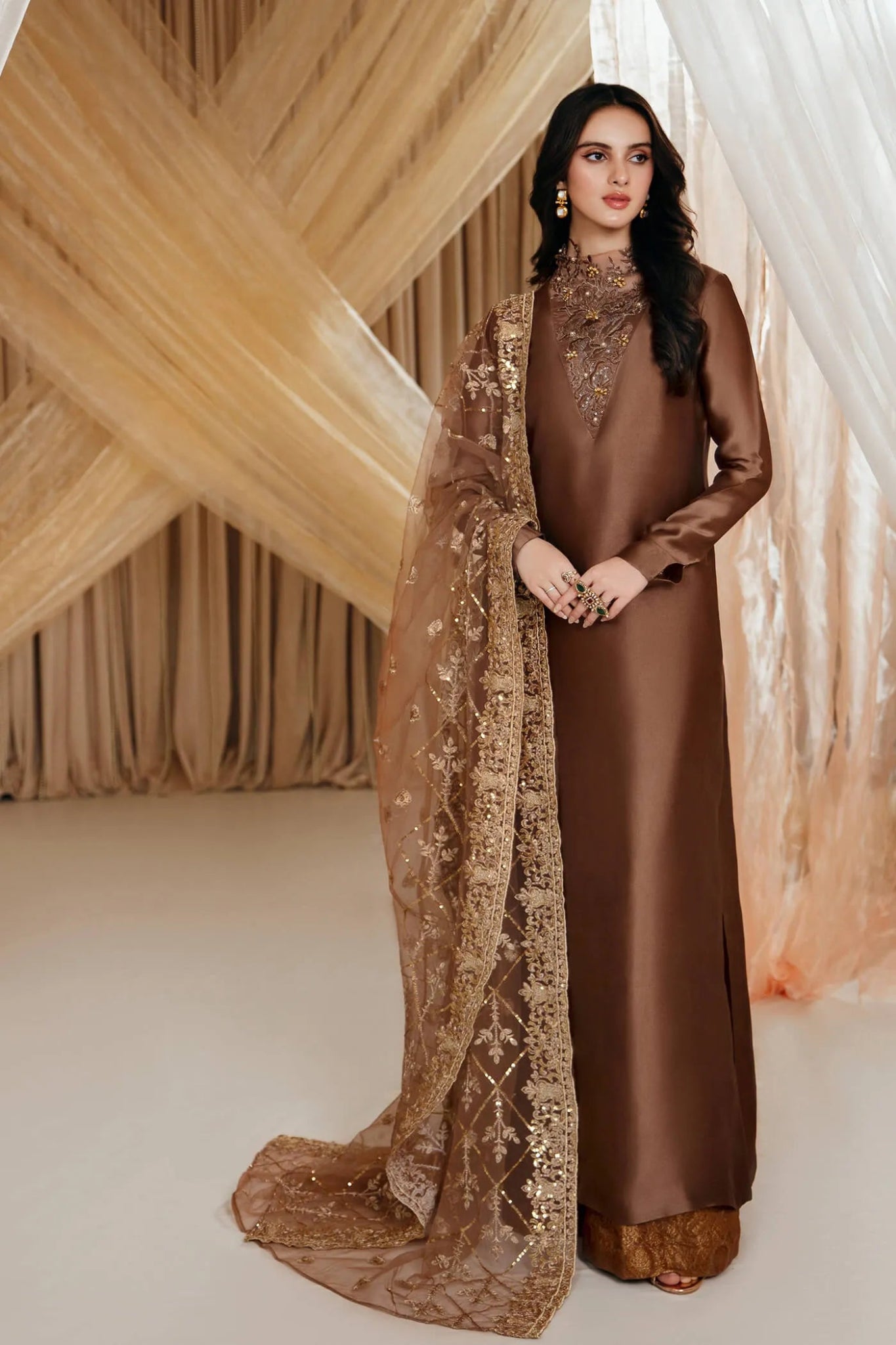 Model wearing a brown ETHEREAL GODDESS dress from Musferah Saad's MYSTERE Eid collection '24, showcasing Pakistani clothes online in the UK.