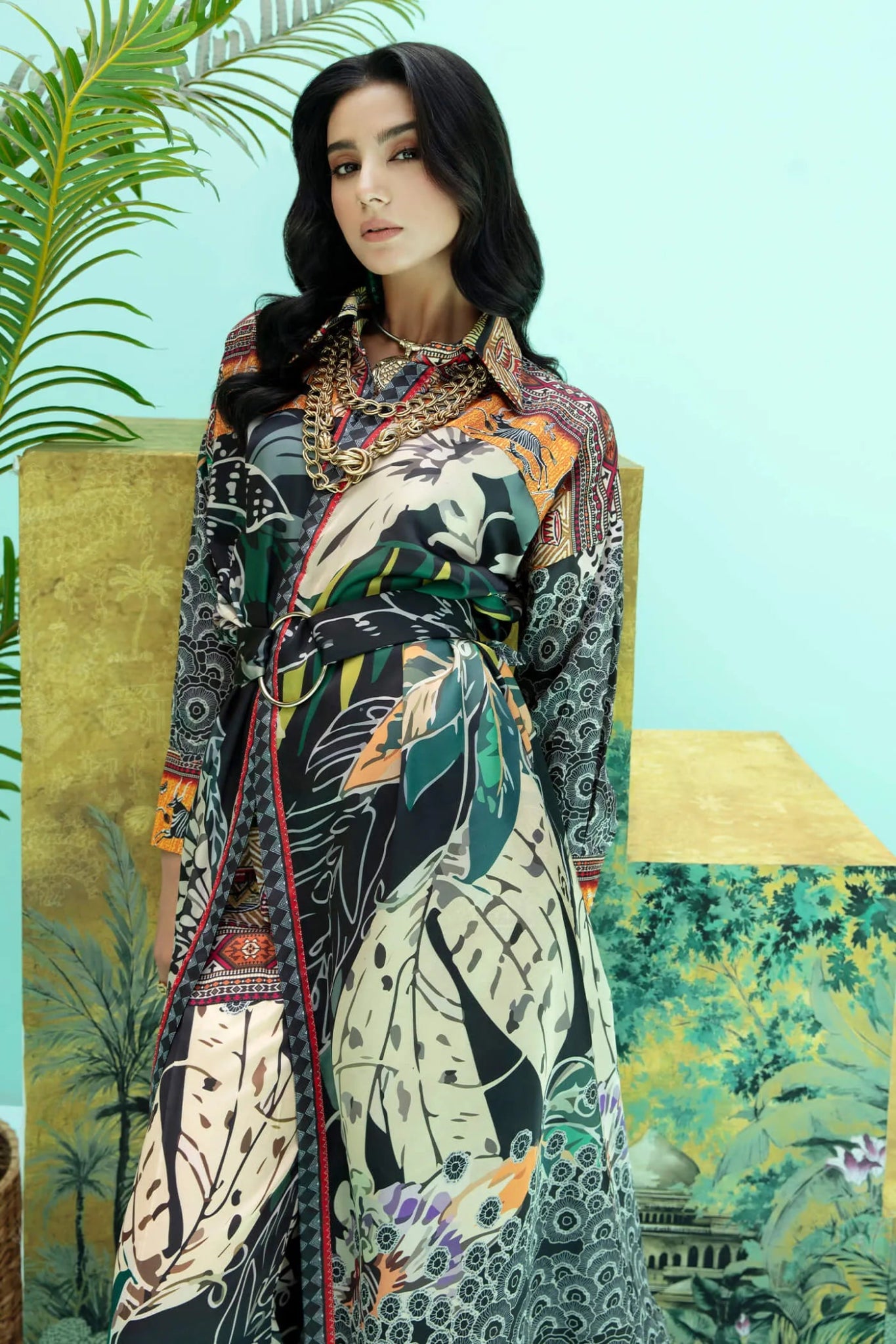 Model wearing a colorful fusion of black, rust, and green SAFARI SWAY dress from Musferah Saad's Resort collection '24, showcasing Pakistani clothes online in the UK.