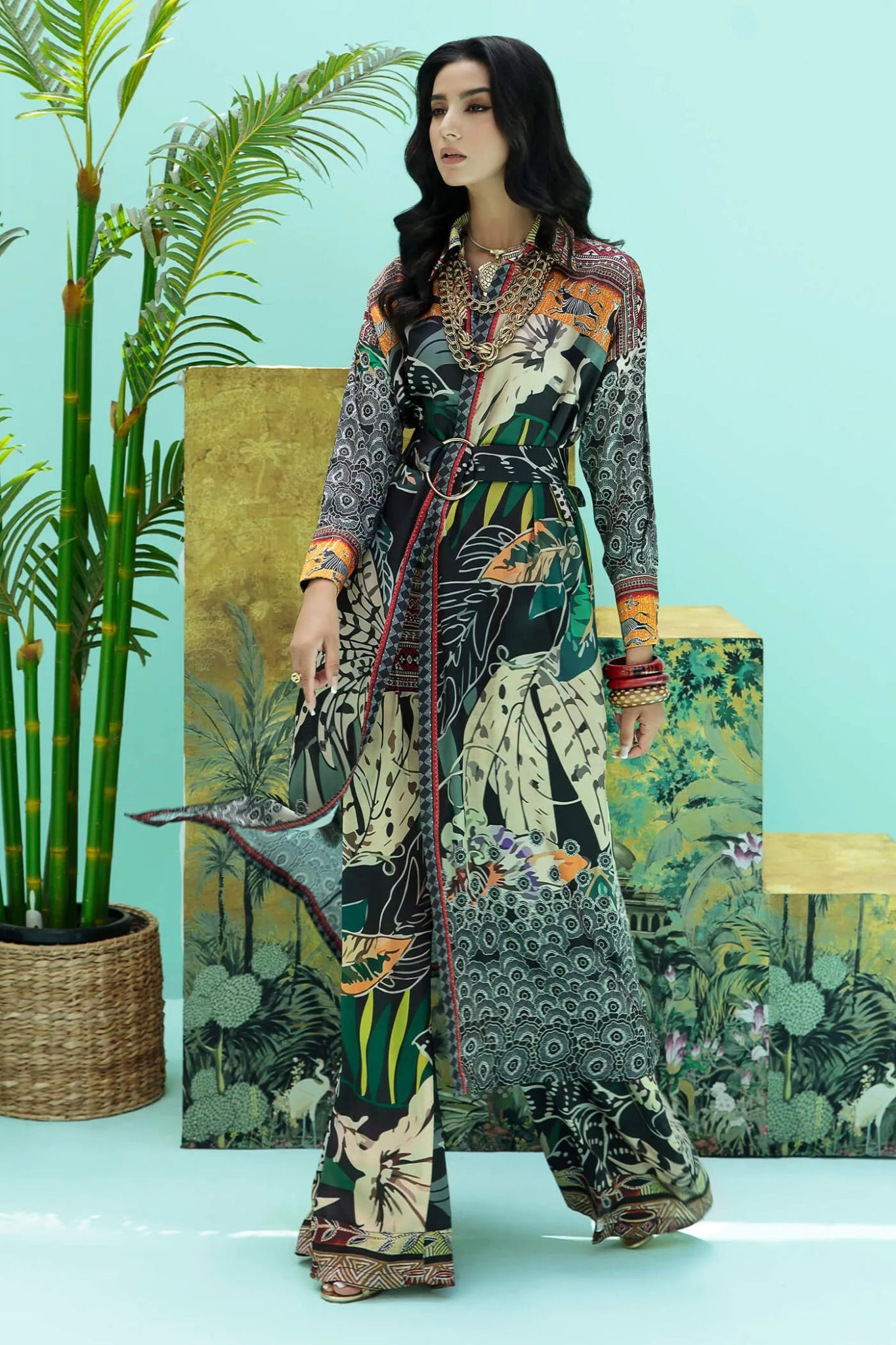 Model wearing a colorful fusion of black, rust, and green SAFARI SWAY dress from Musferah Saad's Resort collection '24, showcasing Pakistani clothes online in the UK.