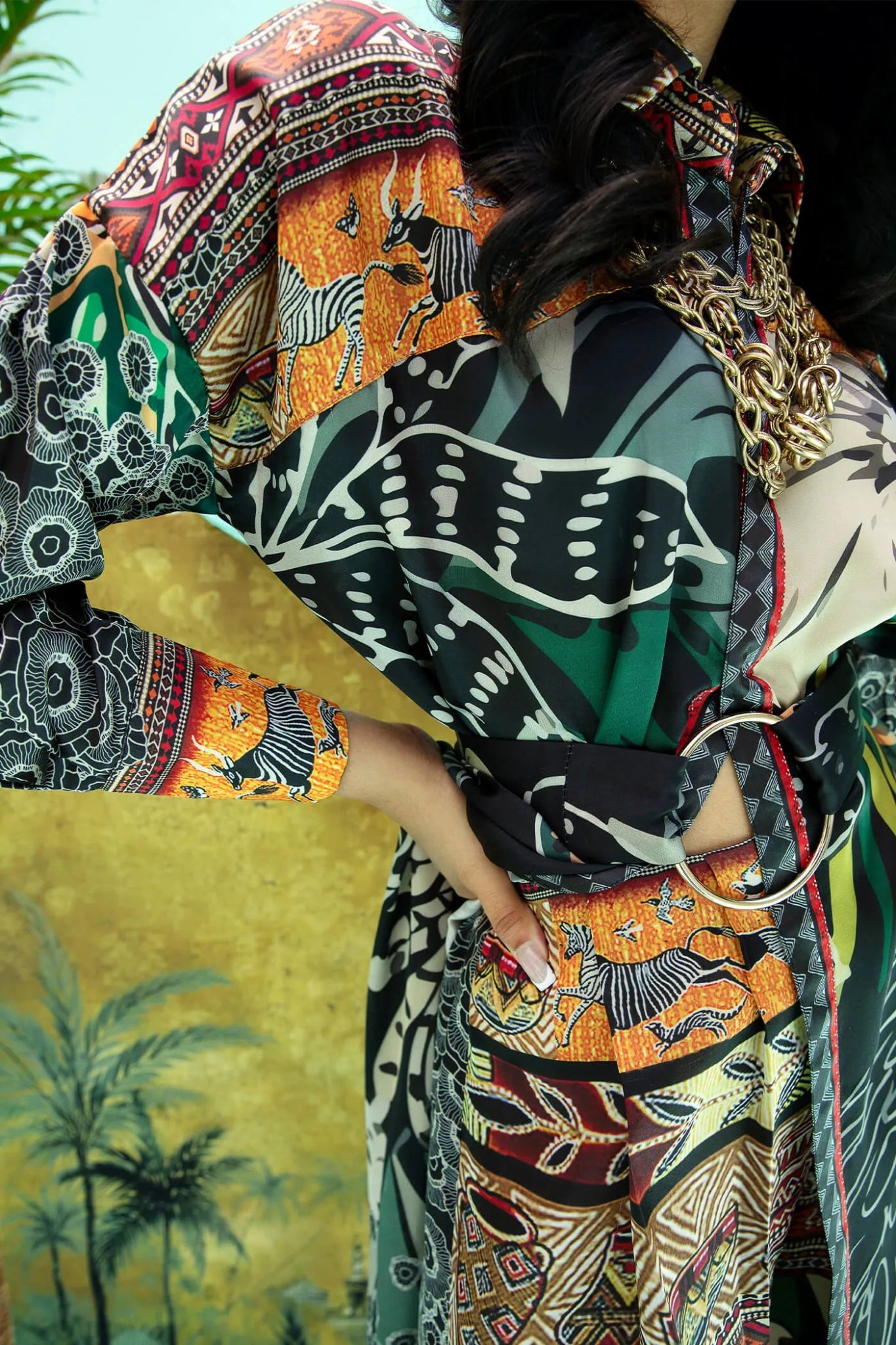 Model wearing a colorful fusion of black, rust, and green SAFARI SWAY dress from Musferah Saad's Resort collection '24, showcasing Pakistani clothes online in the UK.