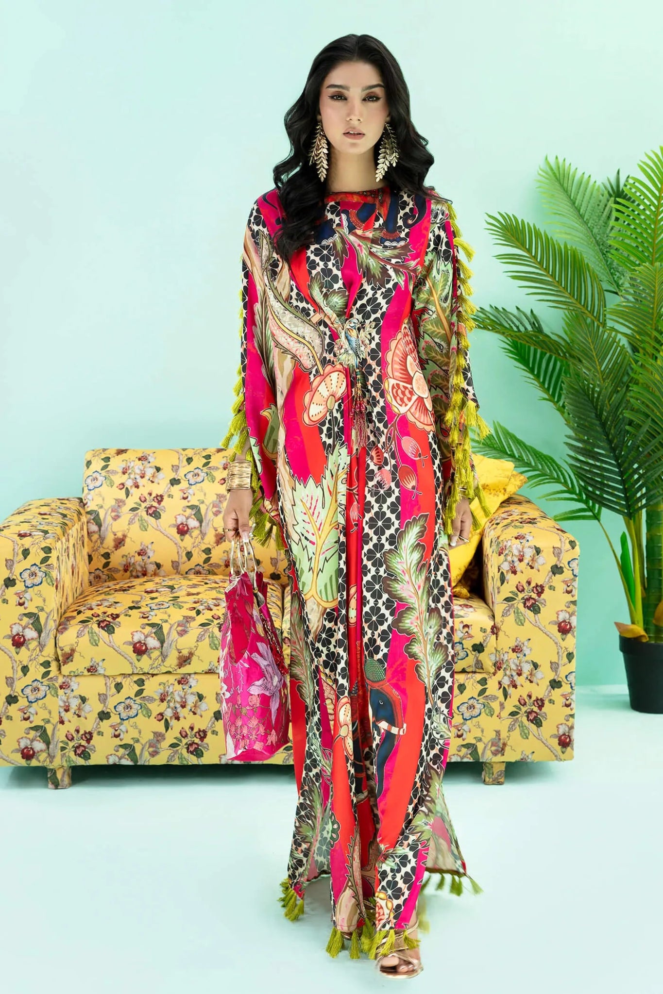 Model wearing a colorful fusion of pink, red, and sage TROPICANO dress from Musferah Saad's Resort collection '24, showcasing Pakistani clothes online in the UK.