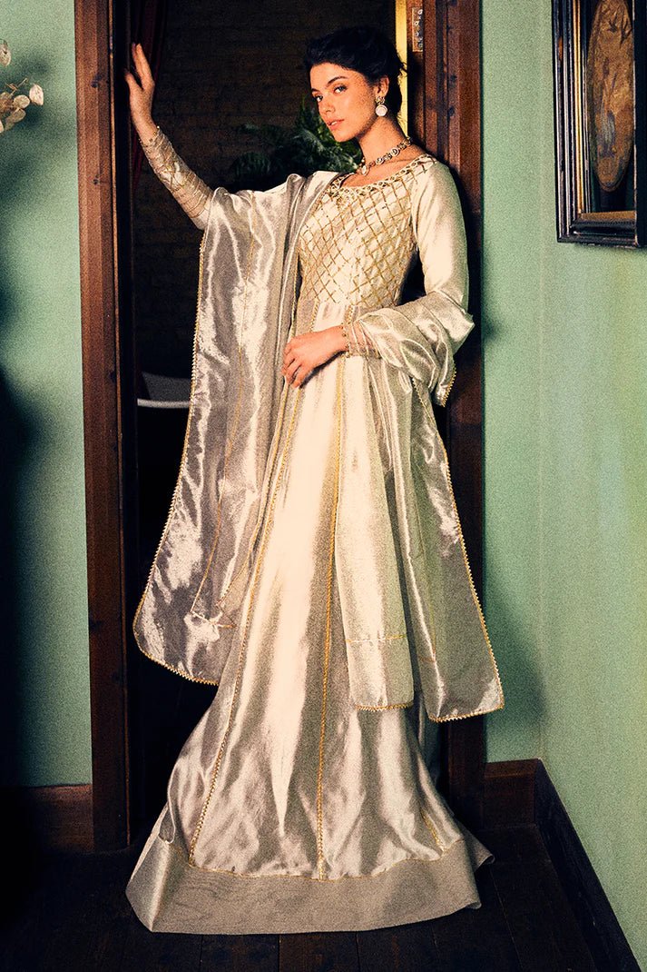 Model wearing a luxurious golden Lashkara dress from Mushq with intricate gota detailing, ideal for Pakistani weddings, available online in the UK.