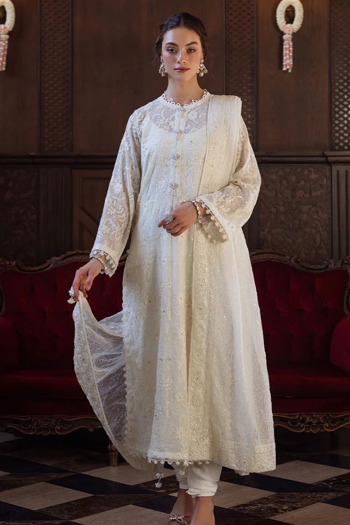 Model wearing ivory LADAN dress from Mushq, Saugaat Chickenkari Pret collection. Pakistani designer clothes in UK, readymade clothes, elegant and stylish.