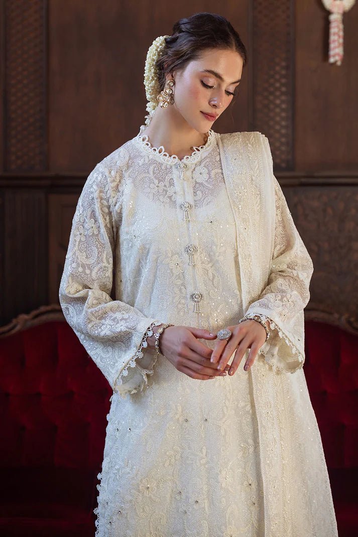 Model wearing ivory LADAN dress from Mushq, Saugaat Chickenkari Pret collection. Pakistani designer clothes in UK, readymade clothes, elegant and stylish.
