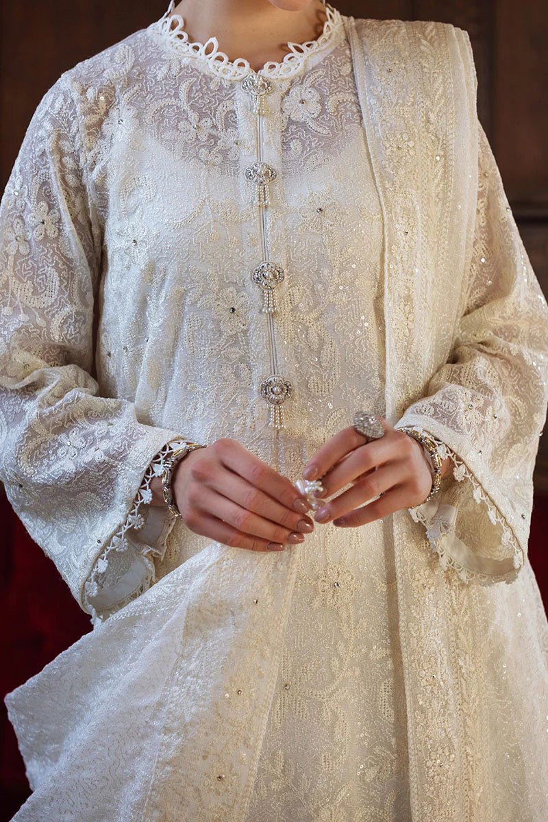 Model wearing ivory LADAN dress from Mushq, Saugaat Chickenkari Pret collection. Pakistani designer clothes in UK, readymade clothes, elegant and stylish.