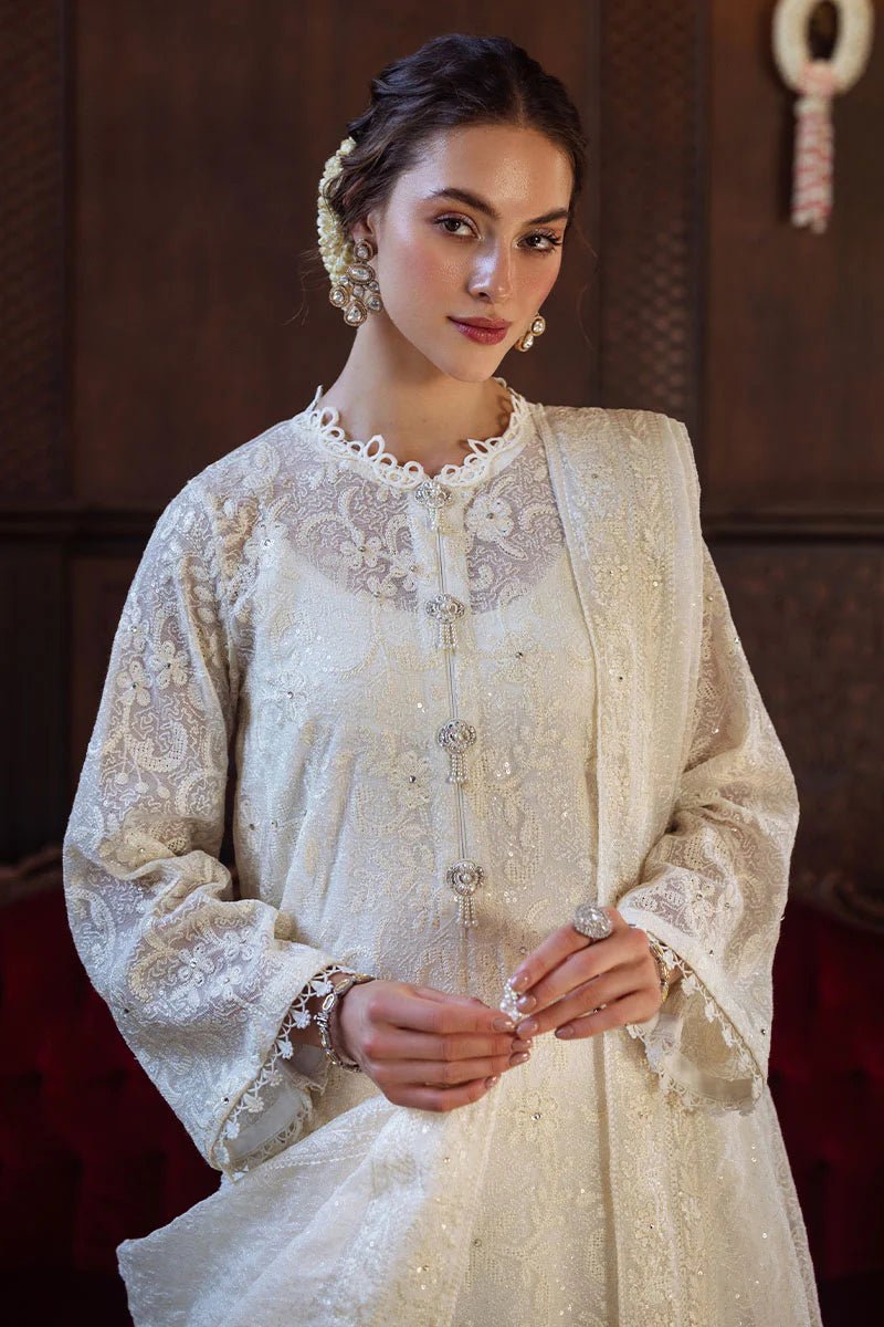 Model wearing ivory LADAN dress from Mushq, Saugaat Chickenkari Pret collection. Pakistani designer clothes in UK, readymade clothes, elegant and stylish.