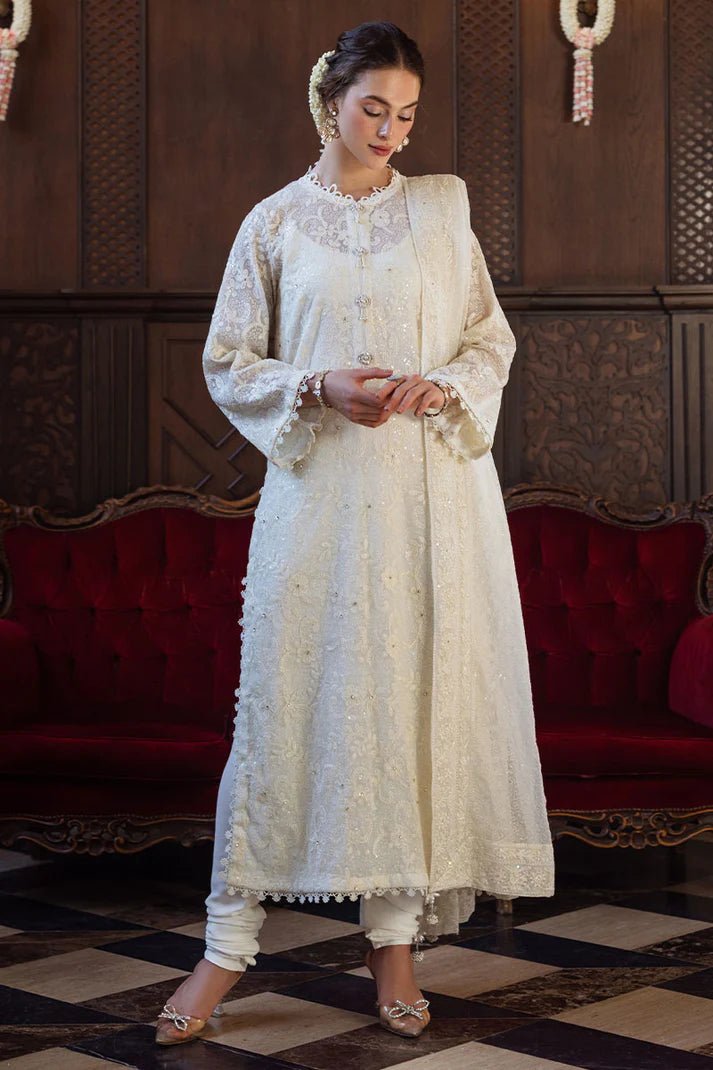 Model wearing ivory LADAN dress from Mushq, Saugaat Chickenkari Pret collection. Pakistani designer clothes in UK, readymade clothes, elegant and stylish.