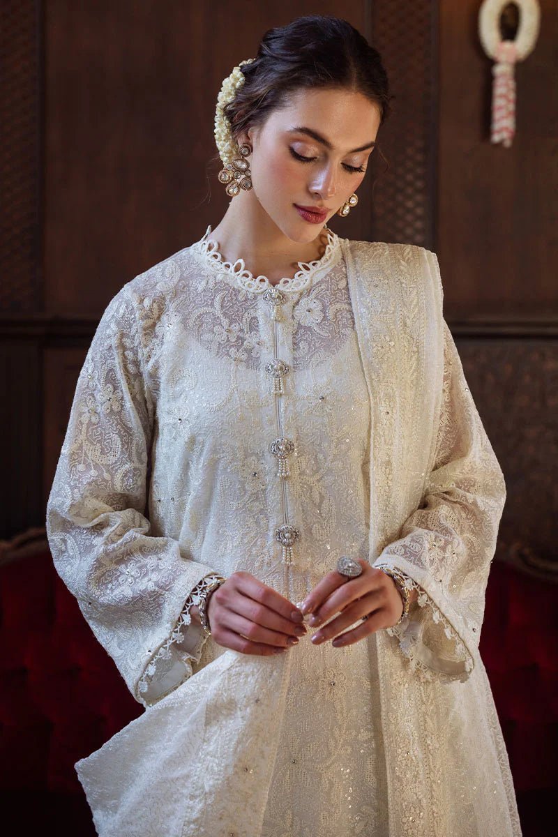 Model wearing ivory LADAN dress from Mushq, Saugaat Chickenkari Pret collection. Pakistani designer clothes in UK, readymade clothes, elegant and stylish.