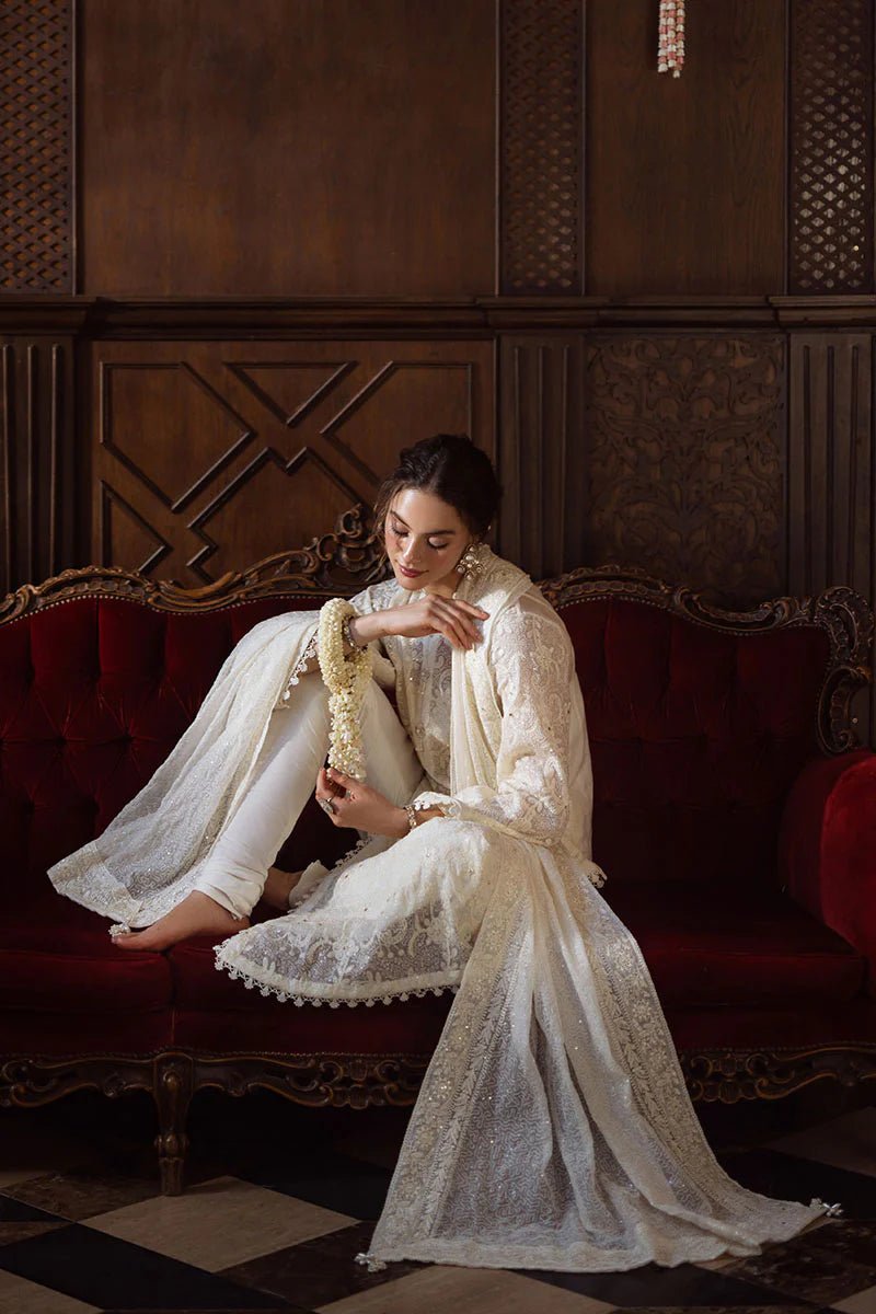 Model wearing ivory LADAN dress from Mushq, Saugaat Chickenkari Pret collection. Pakistani designer clothes in UK, readymade clothes, elegant and stylish.
