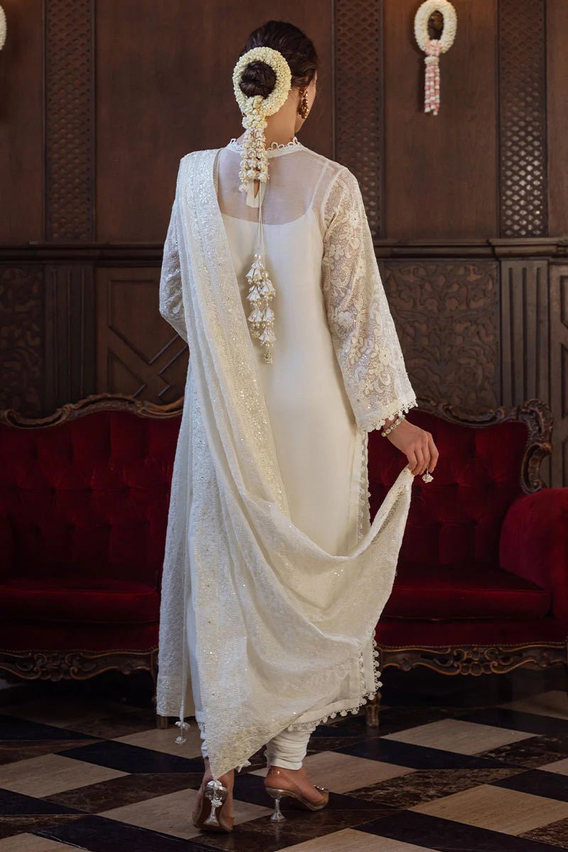 Model wearing ivory LADAN dress from Mushq, Saugaat Chickenkari Pret collection. Pakistani designer clothes in UK, readymade clothes, elegant and stylish.