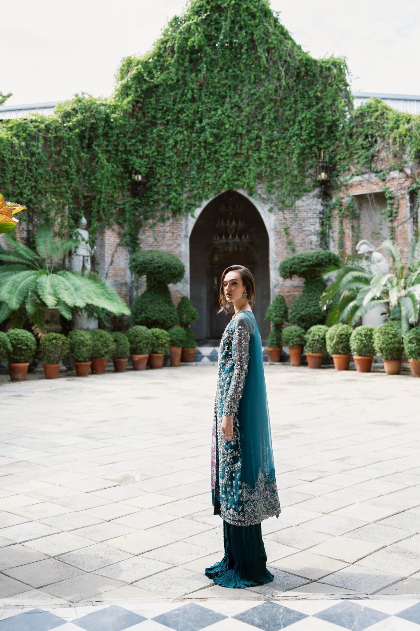 Model wearing Mysie by Tahira AROOB dress in teal, showcasing intricate embroidery and elegant design, perfect for weddings. showcasing Pakistani clothes online in the UK at Signature Labels