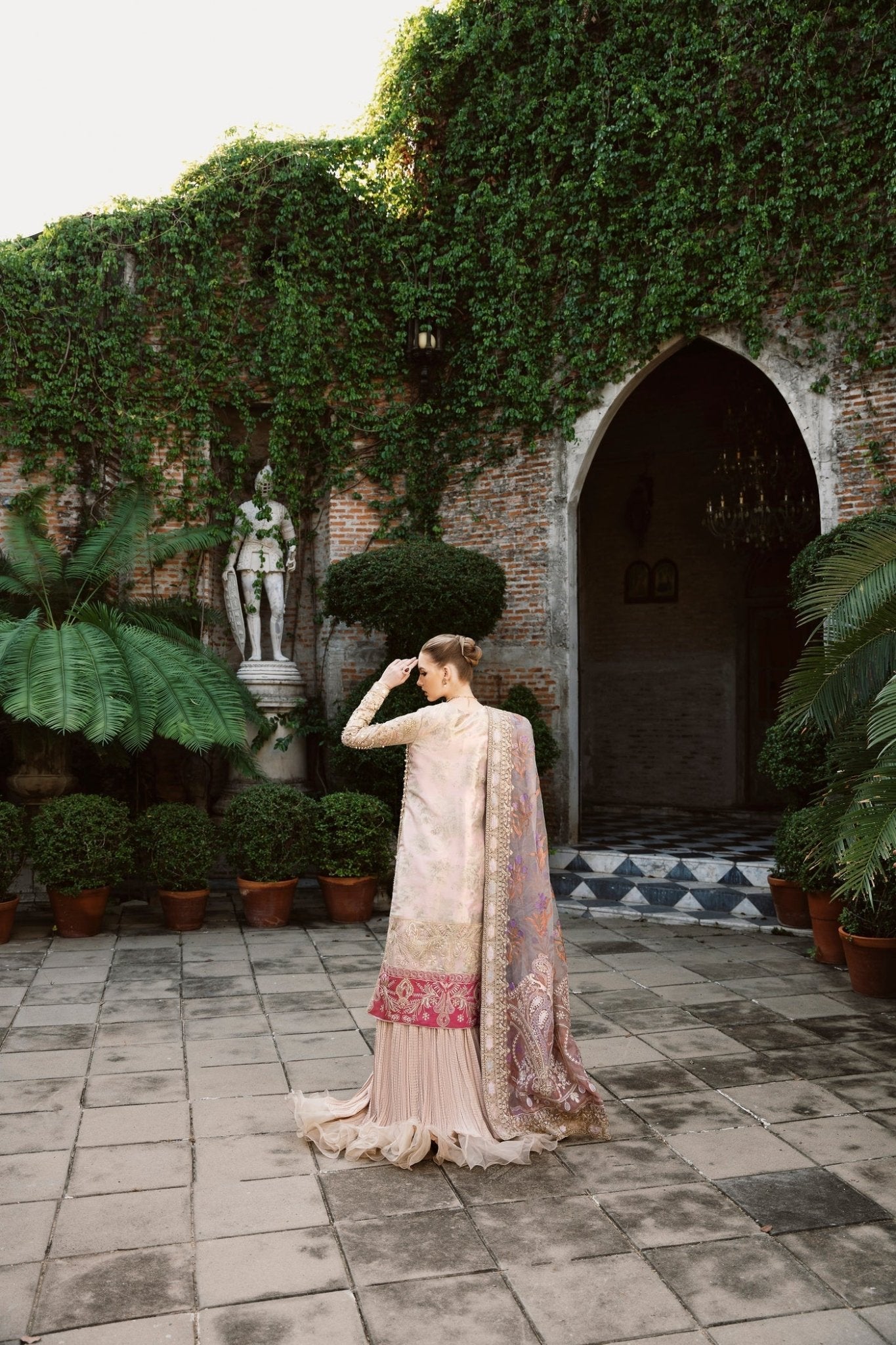 Model wearing a multicolored SHABANA dress with intricate embroidery, featuring shades of beige and red, from Mysie by Tahira. Perfect for Pakistani wedding clothes online in the UK.