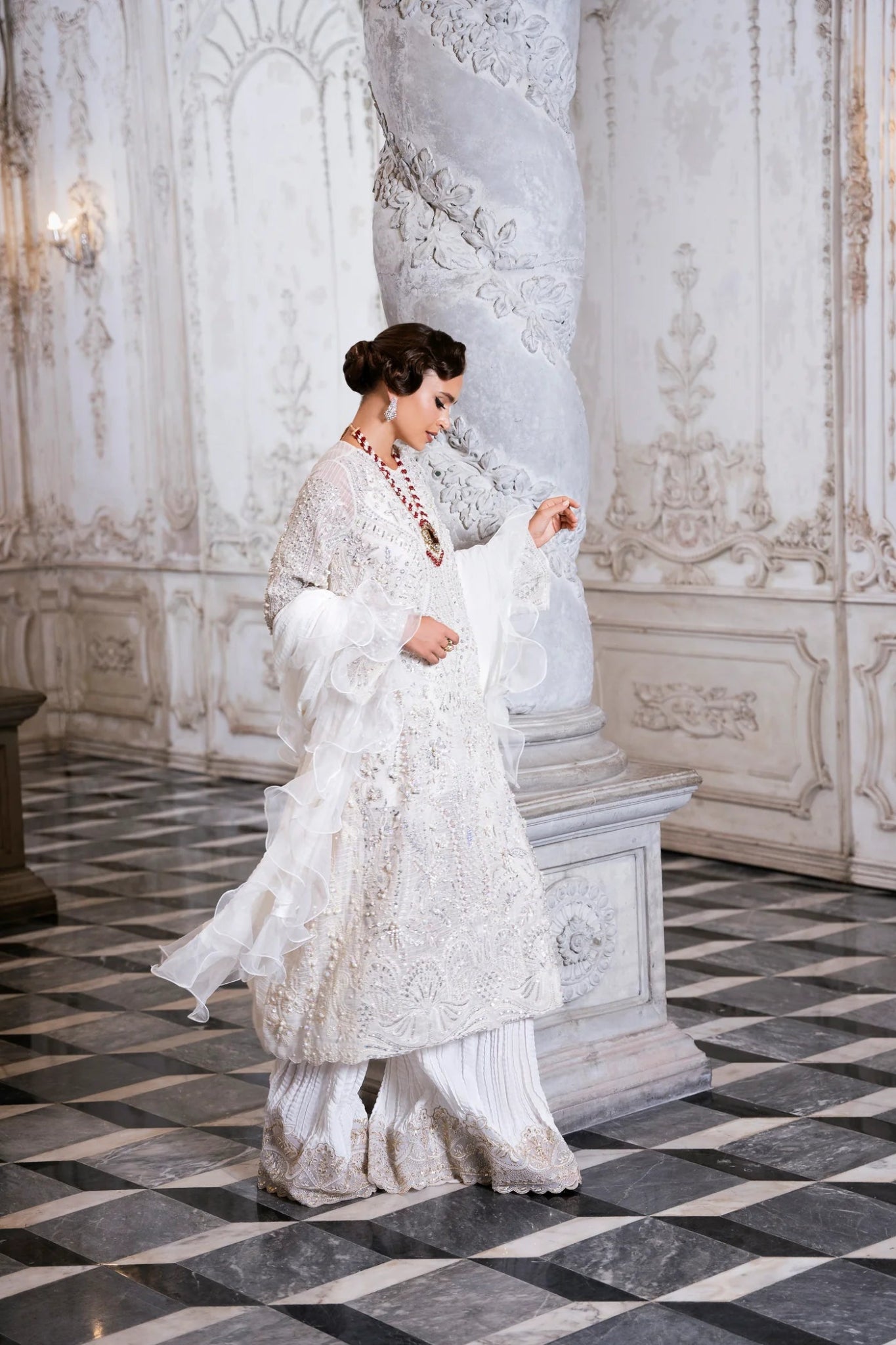 Model wearing SUZANNA ivory dress from Mysie by Tahira, featuring intricate silver embroidery and ruffled sleeves. Ideal for weddings. Find Pakistani clothes online in UK.