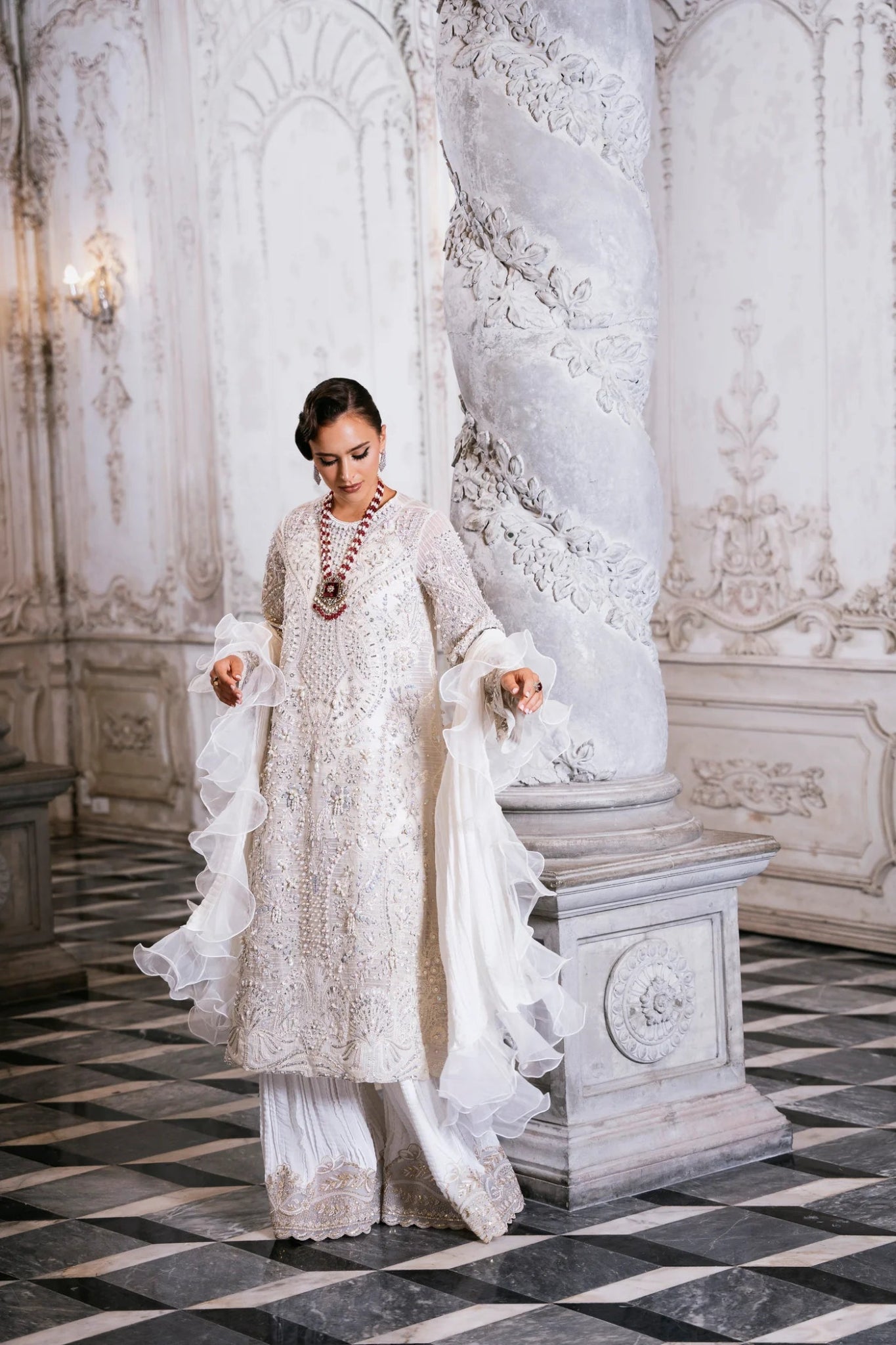 Model wearing SUZANNA ivory dress from Mysie by Tahira, featuring intricate silver embroidery and ruffled sleeves. Ideal for weddings. Find Pakistani clothes online in UK.