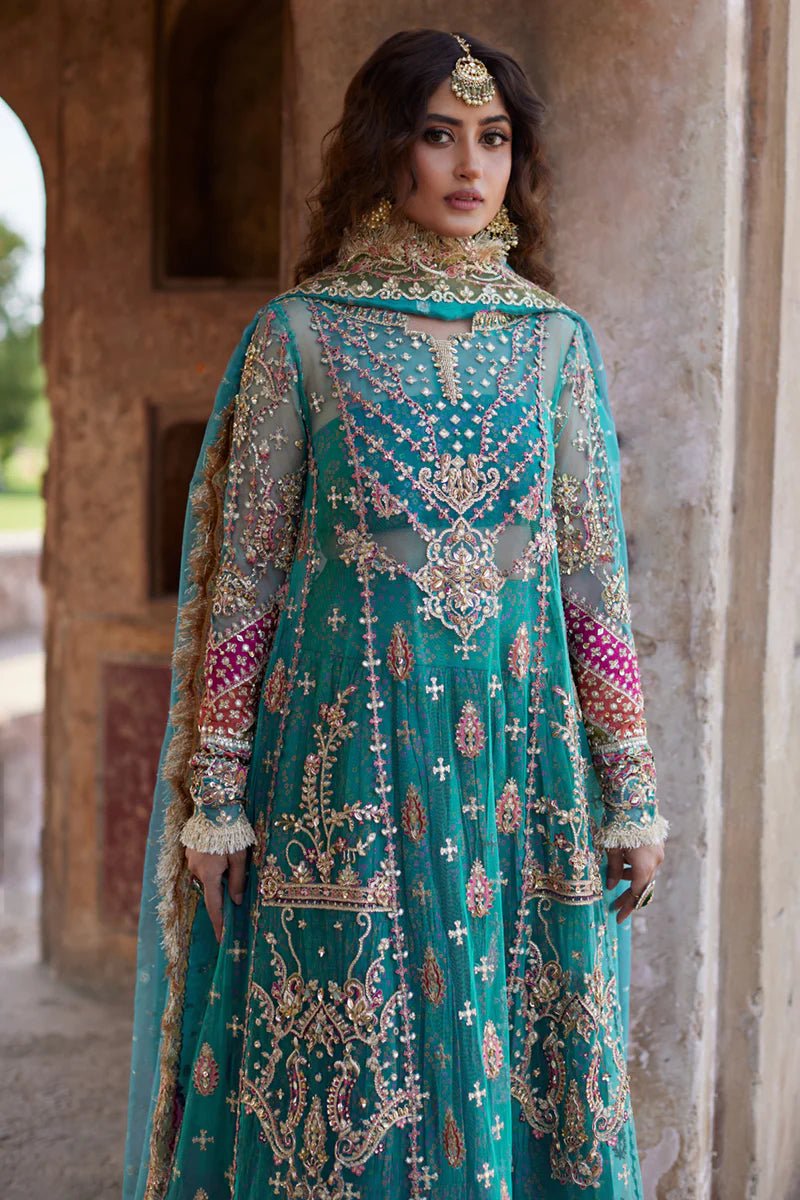 Model wearing Qalamkaar Shadmani Luxury Formals '24 Sama SH - 03 dress in teal with intricate gold embroidery. Shop Pakistani bridal dresses online in the UK now.