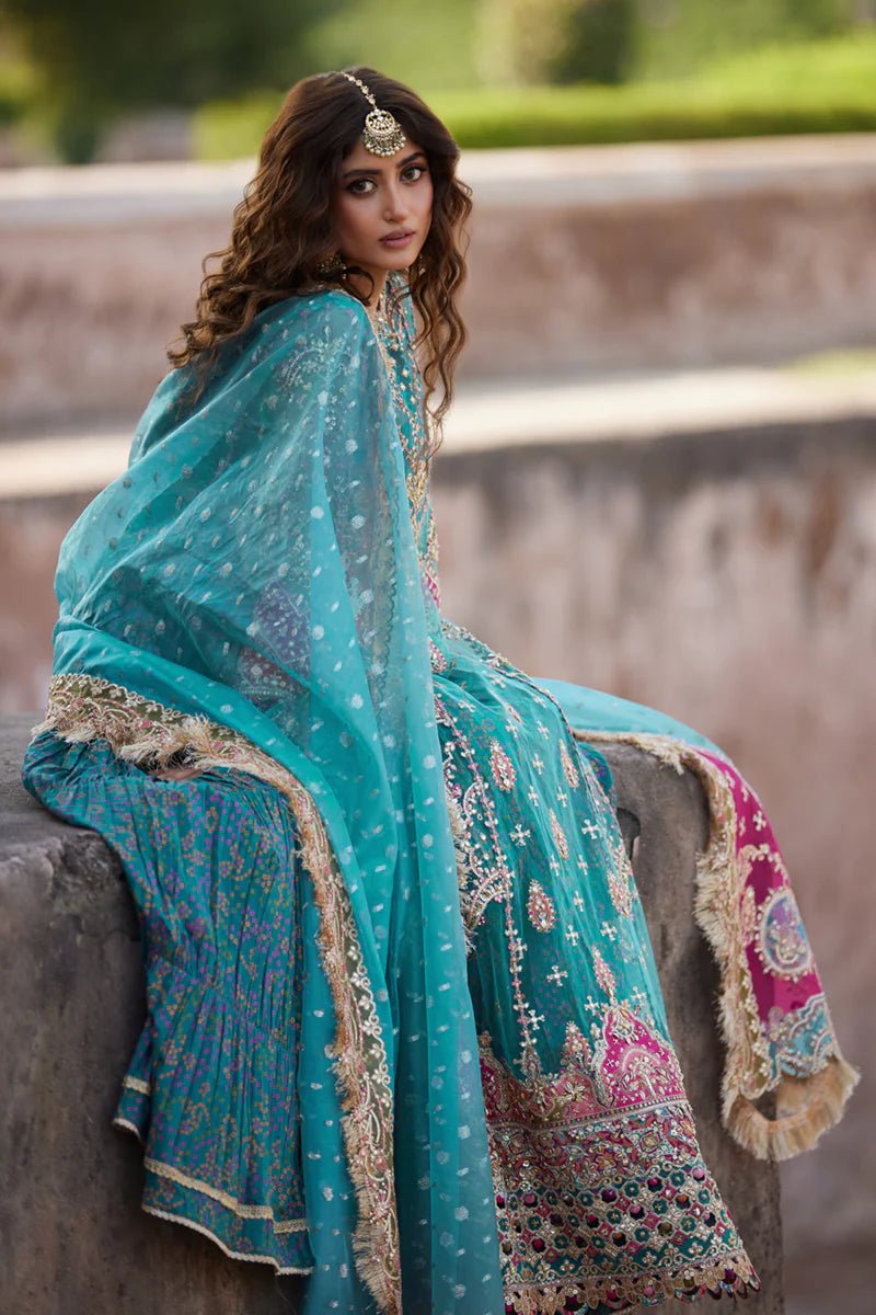 Model wearing Qalamkaar Shadmani Luxury Formals '24 Sama SH - 03 dress in teal with intricate gold embroidery. Shop Pakistani bridal dresses online in the UK now.