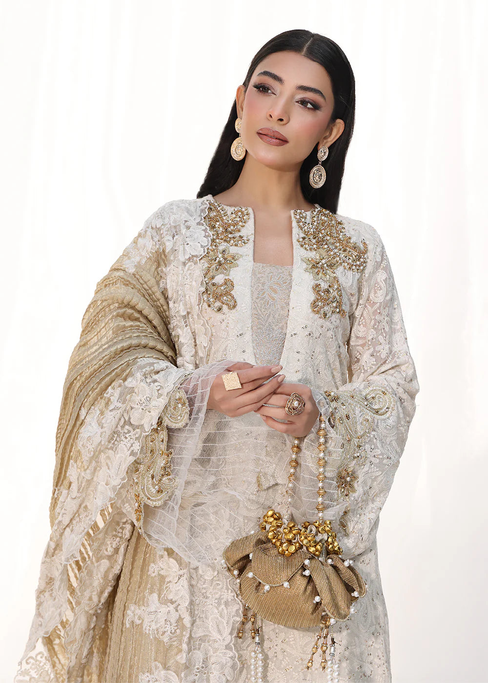 Model wearing off-white and gold embellished dress with lace detailing and dupatta from Musferah Saad Royal Pearl, Pakistani Luxury pret in UK.
