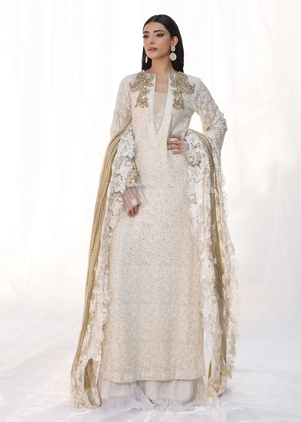 Model wearing off-white and gold embellished dress with lace detailing and dupatta from Musferah Saad Royal Pearl, Pakistani Luxury pret in UK.