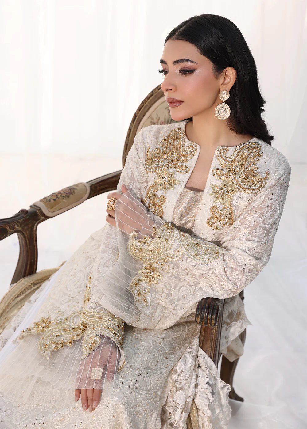 Model wearing off-white and gold embellished dress with lace detailing and dupatta from Musferah Saad Royal Pearl, Pakistani Luxury pret in UK.