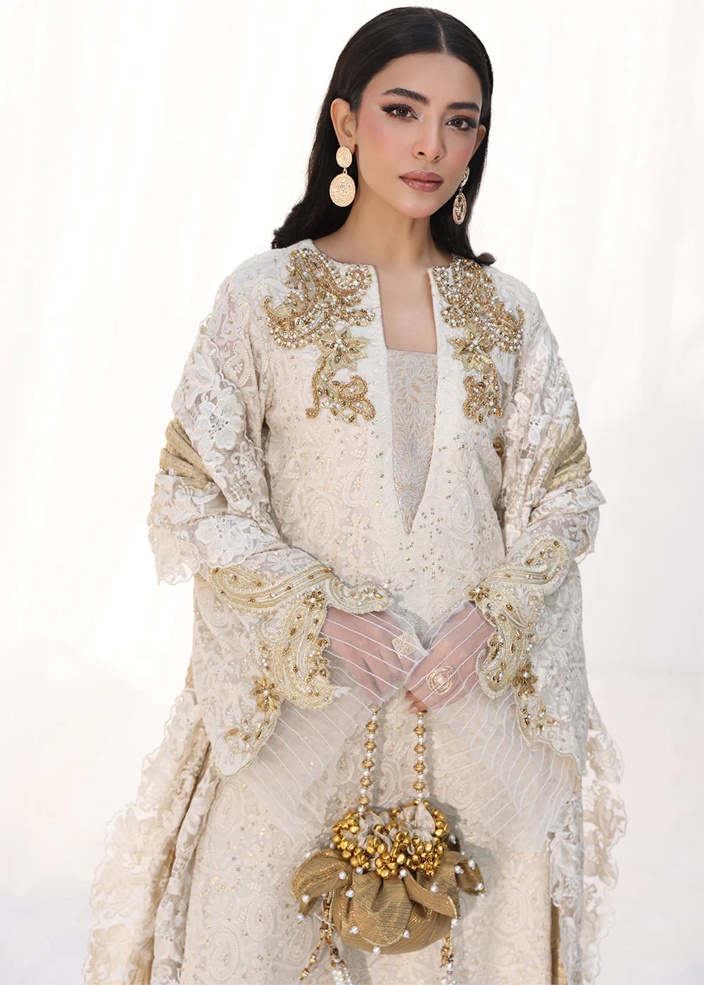 Model wearing off-white and gold embellished dress with lace detailing and dupatta from Musferah Saad Royal Pearl, Pakistani Luxury pret in UK.
