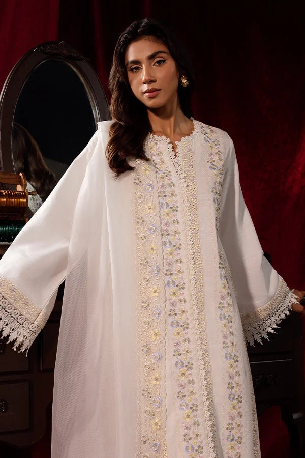 Model wearing a white Pearlescent dress from Saffron, adorned with intricate embroidery, ideal for winter, showcasing Pakistani designer clothes online in the UK.