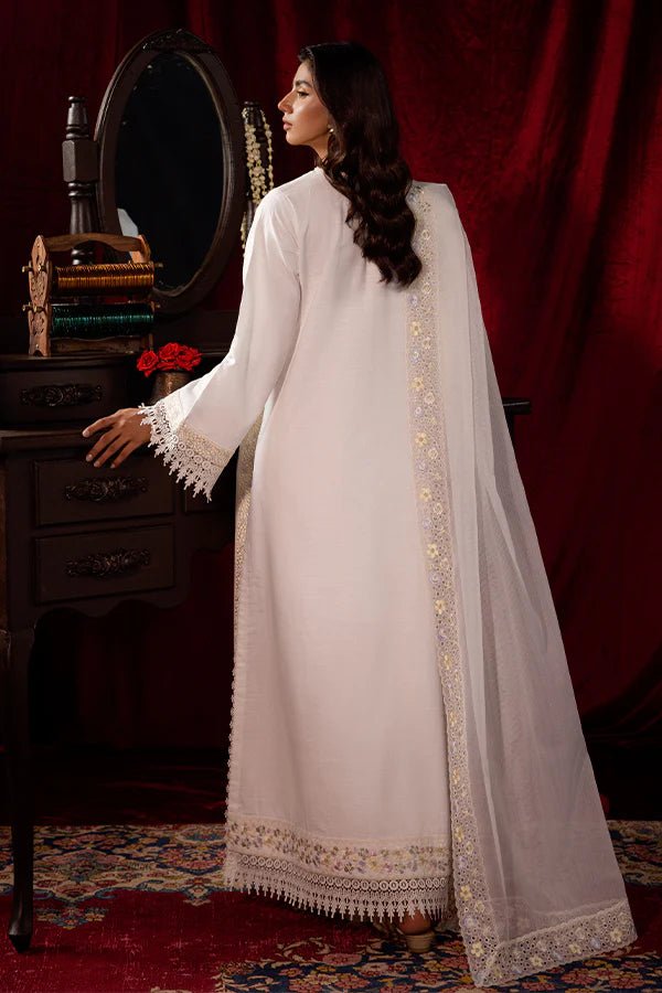 Model wearing a white Pearlescent dress from Saffron, adorned with intricate embroidery, ideal for winter, showcasing Pakistani designer clothes online in the UK.