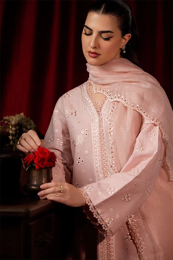 Model wearing a soft pink Petal Mist dress from Saffron, adorned with delicate embroidery, showcasing Pakistani designer clothes online in the UK, perfect for winter.