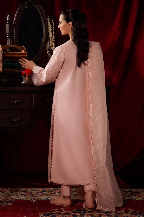 Model wearing a soft pink Petal Mist dress from Saffron, adorned with delicate embroidery, showcasing Pakistani designer clothes online in the UK, perfect for winter.