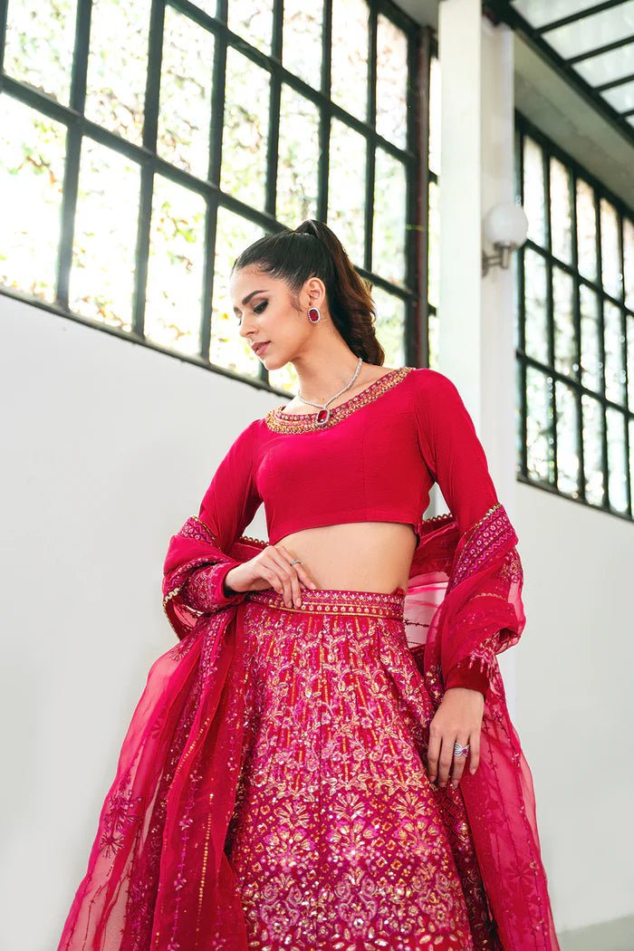 Model wearing a red SRN24 - 04 SHARMAS lehenga choli from Saira Rizwan's Naqsh Festive '24 collection. Available online in the UK, perfect for weddings.