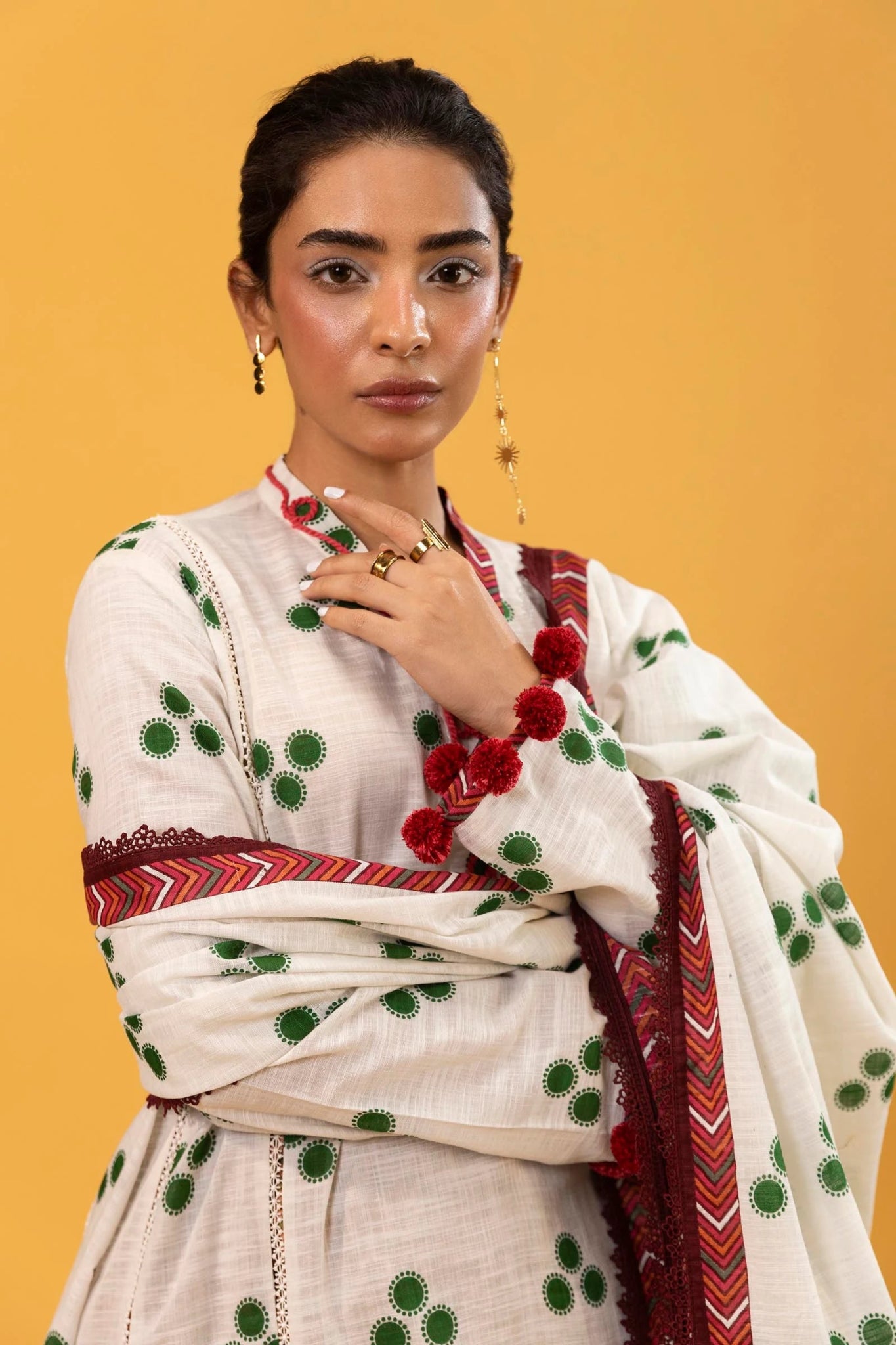 Model wearing Sana Safinaz Mahay Winter '24, showcasing a white and yellow with hues of green 3 - piece outfit with embroidery and intricate printing, ideal for winter casual pret. Available online in the UK.