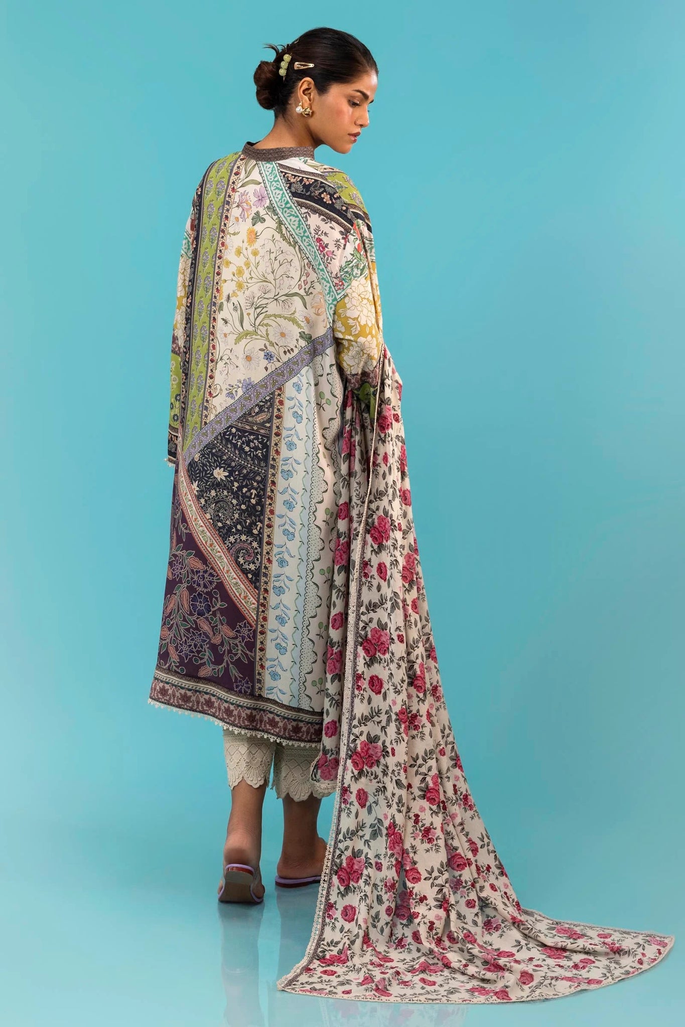 Model wearing a two - piece Sana Safinaz suit from the Mahay Winter '24 collection, featuring a digitally printed linen shirt with mixed floral and geometric patterns, paired with a coordinating rotary printed linen dupatta. Available online in the UK.
