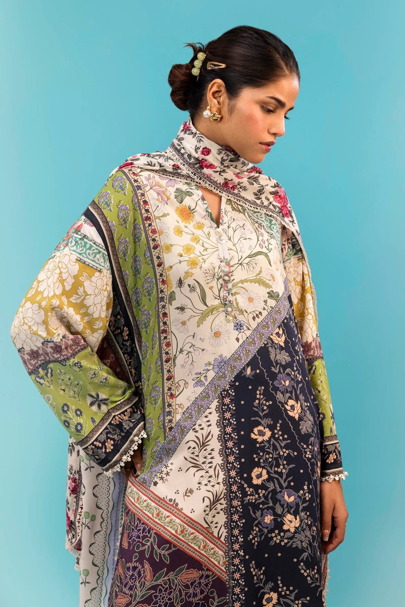 Model wearing a two - piece Sana Safinaz suit from the Mahay Winter '24 collection, featuring a digitally printed linen shirt with mixed floral and geometric patterns, paired with a coordinating rotary printed linen dupatta. Available online in the UK.