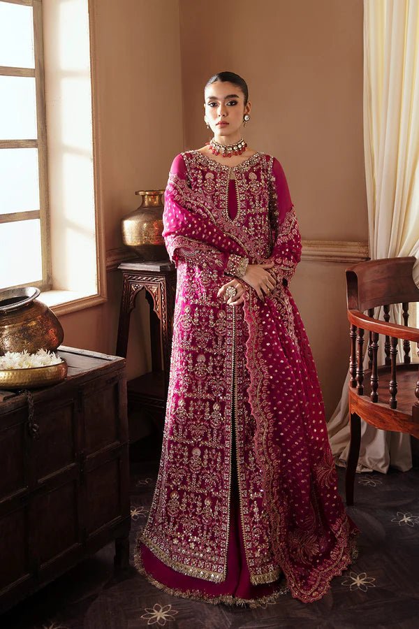Model wearing RAIZEL dress in rich magenta from Soraya. Perfect for weddings, highlighting intricate embroidery and luxurious design. Buy Pakistani clothes online in UK from Soraya.