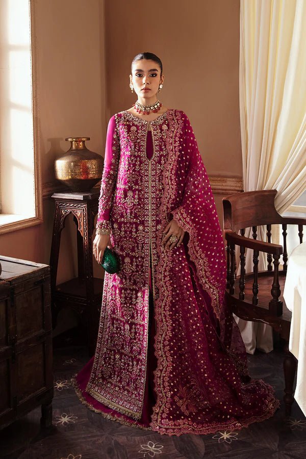 Model wearing RAIZEL dress in rich magenta from Soraya. Perfect for weddings, highlighting intricate embroidery and luxurious design. Buy Pakistani clothes online in UK from Soraya.