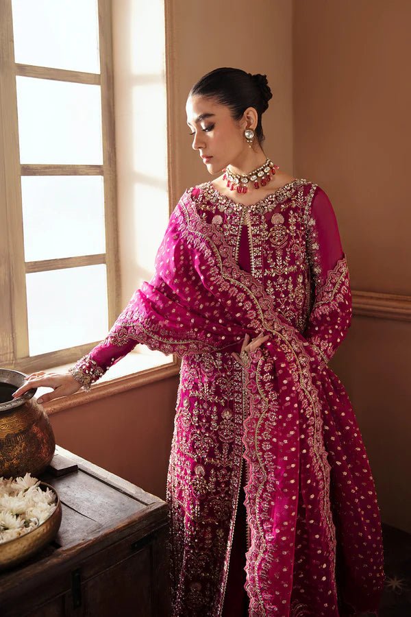 Model wearing RAIZEL dress in rich magenta from Soraya. Perfect for weddings, highlighting intricate embroidery and luxurious design. Buy Pakistani clothes online in UK from Soraya.