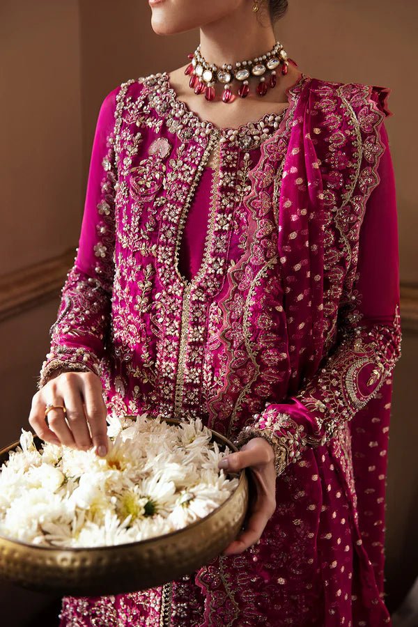 Model wearing RAIZEL dress in rich magenta from Soraya. Perfect for weddings, highlighting intricate embroidery and luxurious design. Buy Pakistani clothes online in UK from Soraya.
