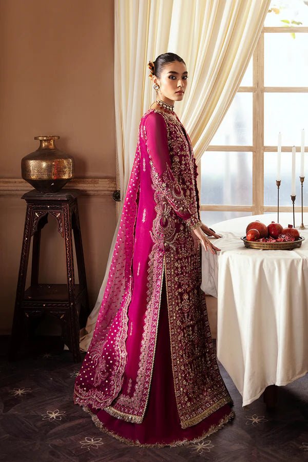 Model wearing RAIZEL dress in rich magenta from Soraya. Perfect for weddings, highlighting intricate embroidery and luxurious design. Buy Pakistani clothes online in UK from Soraya.