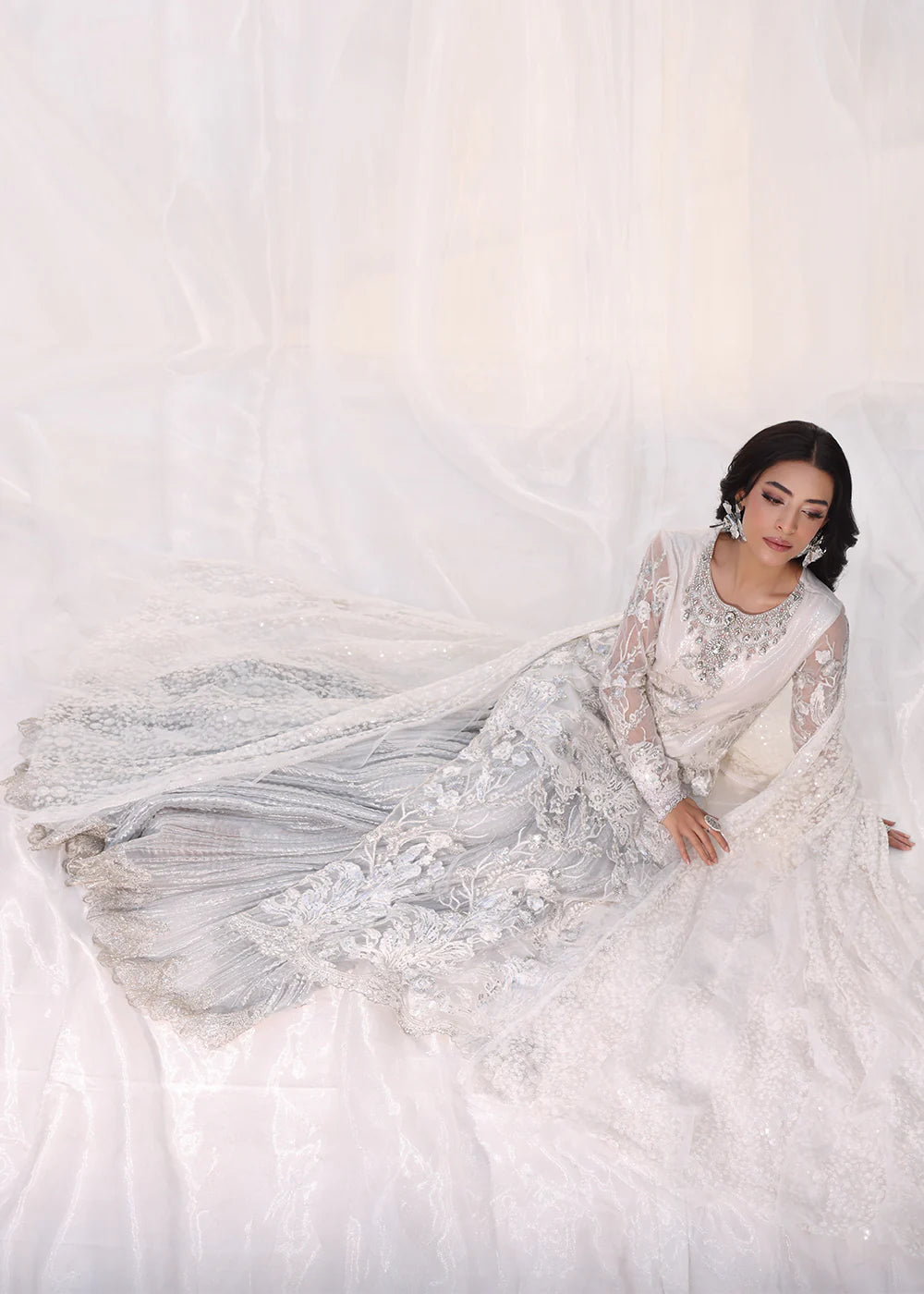 Model wearing silver and white embroidered dress with net dupatta from Musferah Saad Starlit, Pakistani Luxury pret available online in UK.