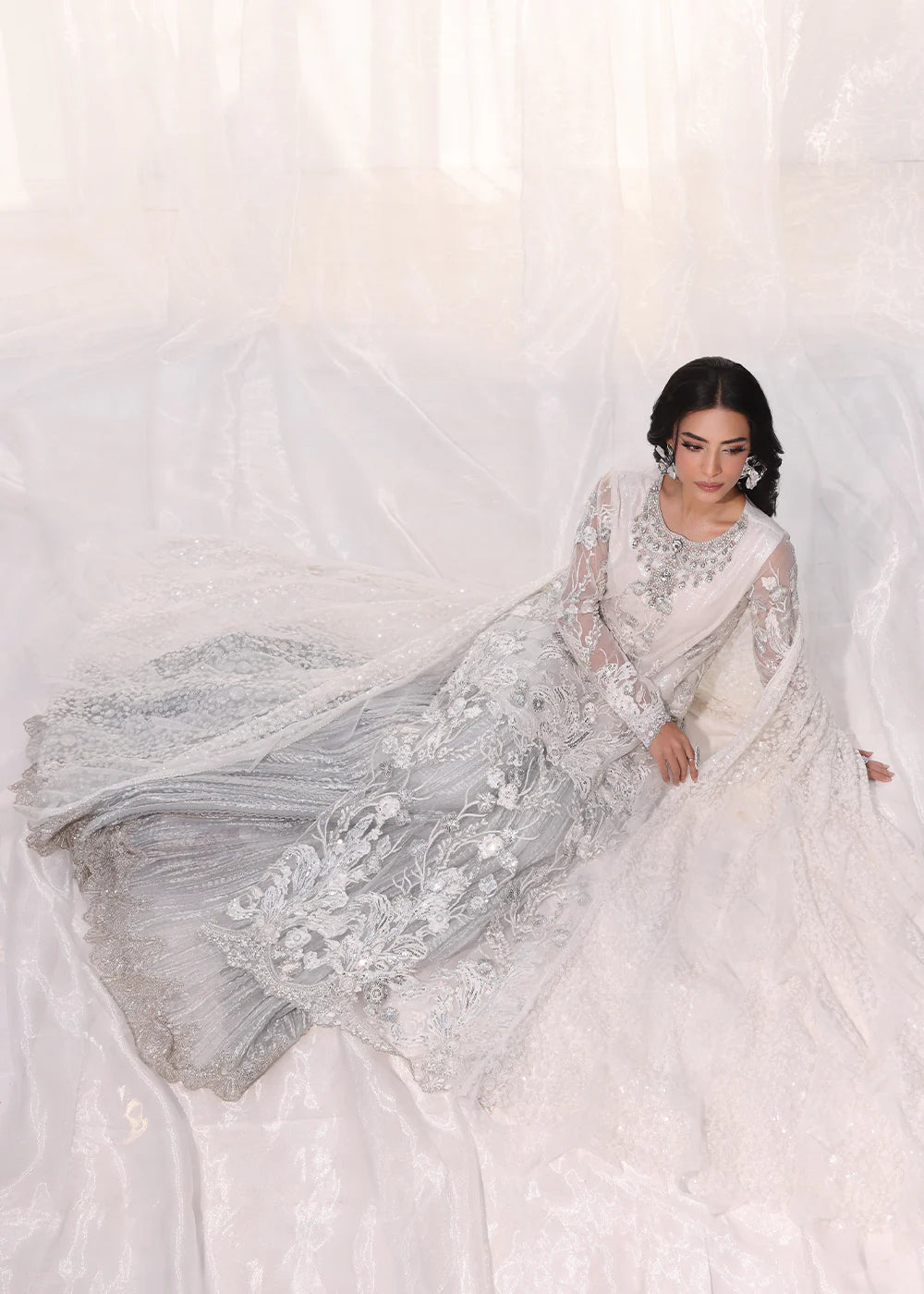 Model wearing silver and white embroidered dress with net dupatta from Musferah Saad Starlit, Pakistani Luxury pret available online in UK.