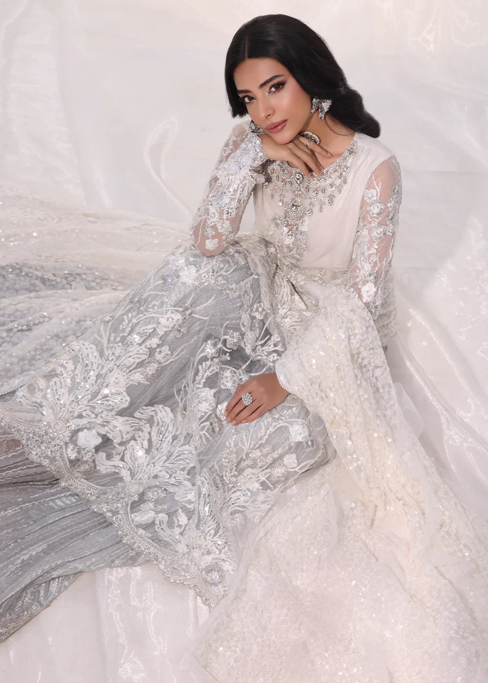 Model wearing silver and white embroidered dress with net dupatta from Musferah Saad Starlit, Pakistani Luxury pret available online in UK.