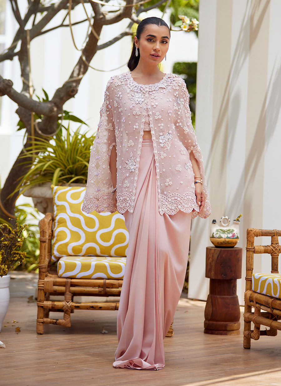 Effortless grace meets artistic craftsmanship in this straight long shirt ensemble. Delicately scattered across the fabric, floral motifs are rendered in intricate embroidery designed to mimic the softness and nuance of pencil colour shading. These artistic blooms are further elevated with delicate silver hand-work and subtle self-colored sequins, creating a harmonious blend of texture and light. The neckline and collar are trimmed with a scalloped border, hand-embellished with classic mukesh work, adding a
